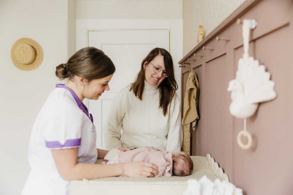 Kraamverzorgende helpt baby en kraamvrouw tijdens de kraamweek met Naviva Kraamzorg.