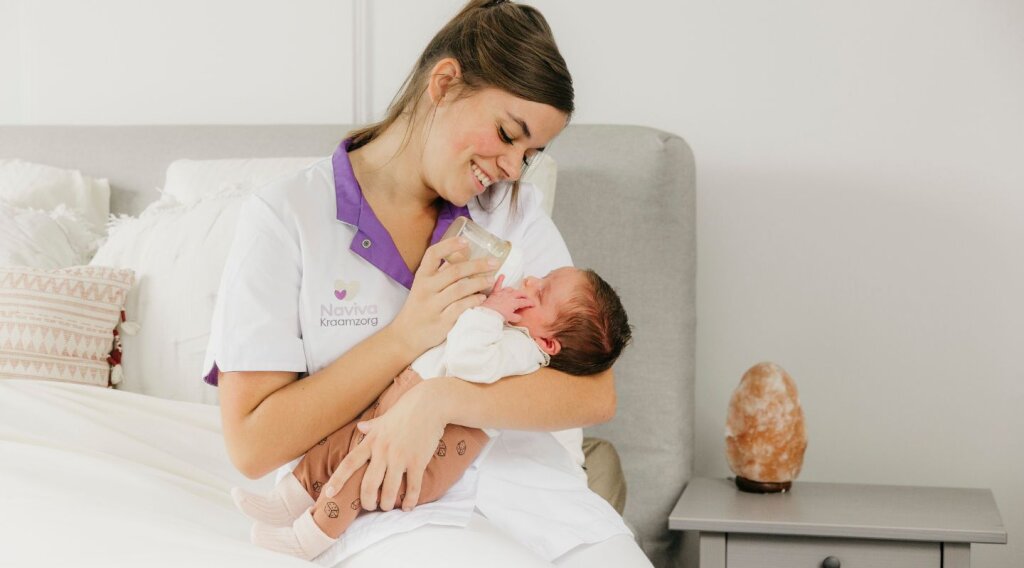 Naviva kraamzorg kraamverzorgende met baby flesje geven.