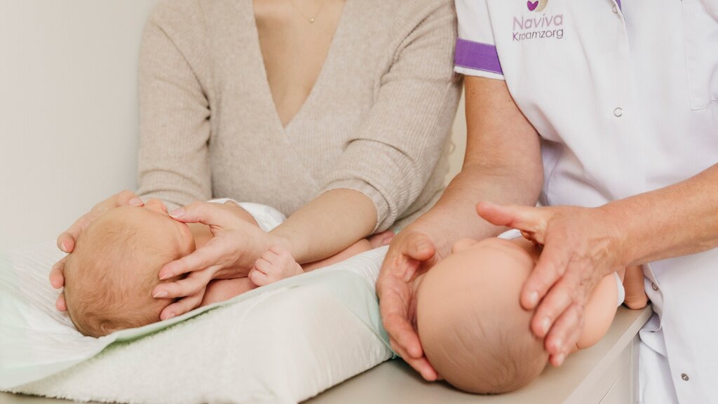 Kraamverzorgende van Naviva kraamzorg doet de baby massage voor.